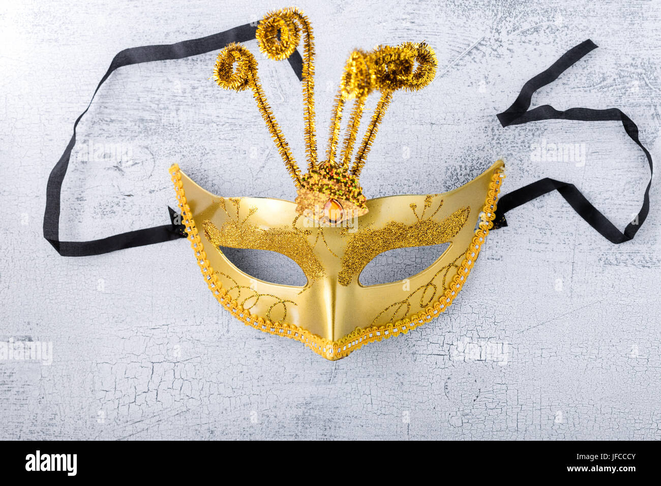 Oro maschera di Carnevale su uno sfondo bianco. Foto Stock
