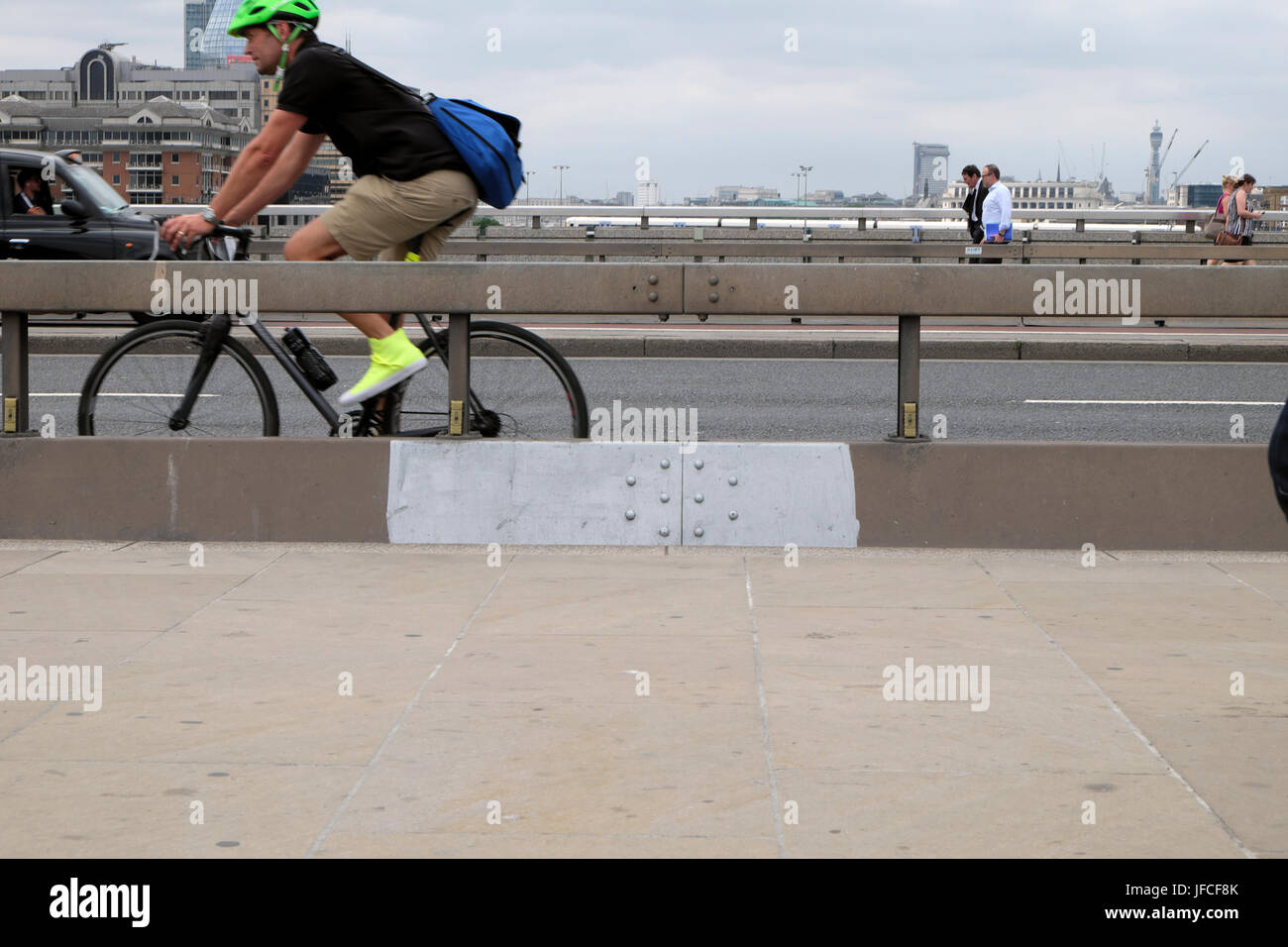 Ciclista di " commuters " Ciclismo su London Bridge accanto a anti-terrorismo di barriera in cemento dopo l attacco di coltello a Borough Market 3 giugno 2017 UK KATHY DEWITT Foto Stock