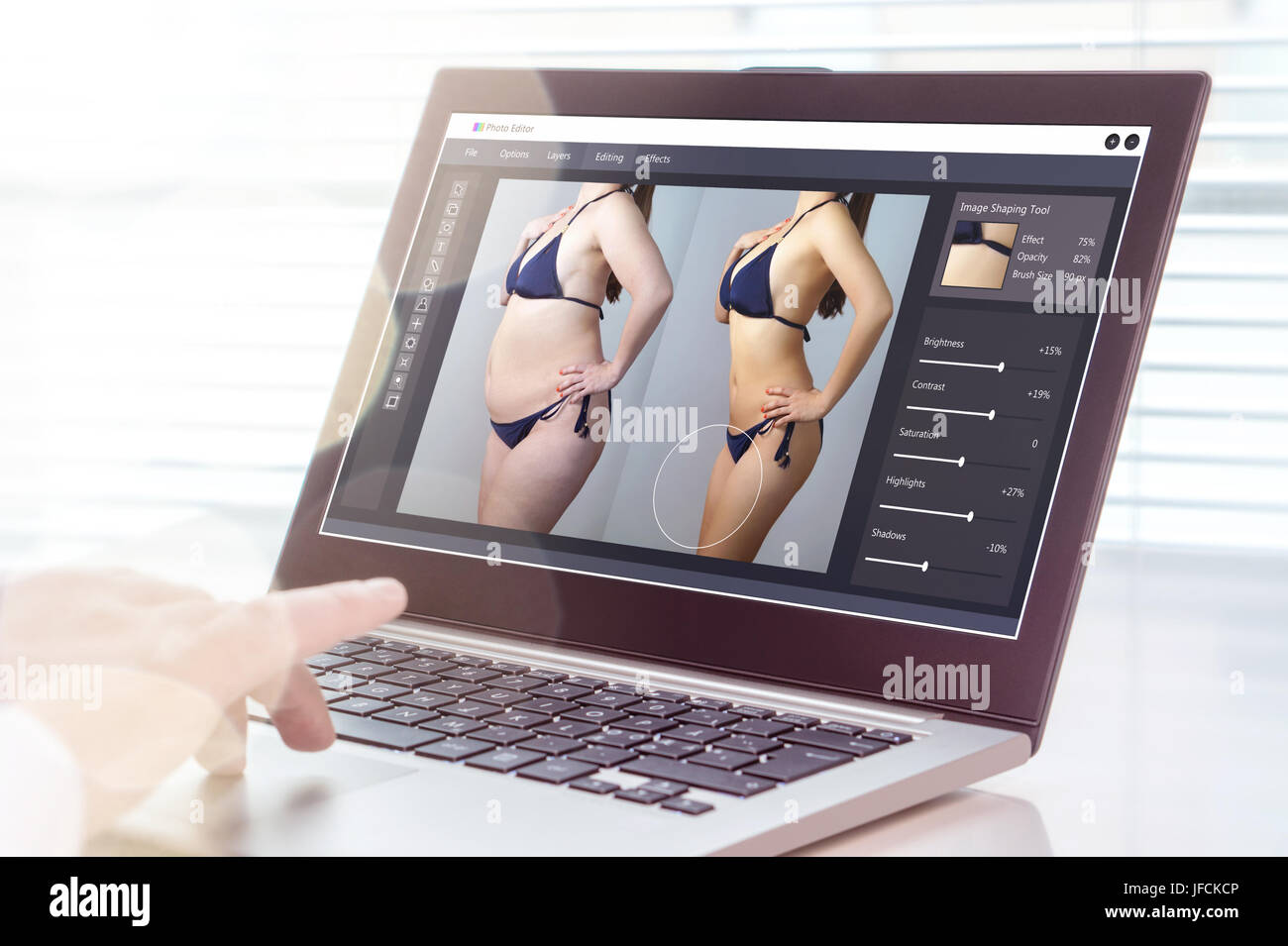Professional uomo utilizzando laptop per trasformare chubby donna slim. Heavy editing di foto con il software del computer. Standard di bellezza e immagine del corpo. Foto Stock
