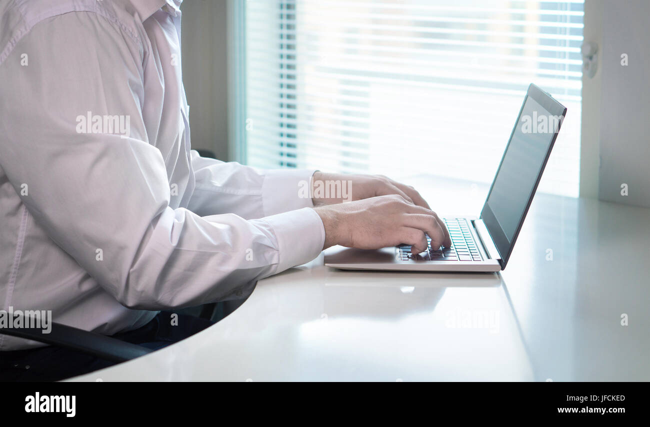 Lavoratore di ufficio o imprenditore digitazione e scrivendo con il notebook portatile nel luogo di lavoro. Avviare il businessman di rispondere a un messaggio di posta elettronica o di commentare. Foto Stock