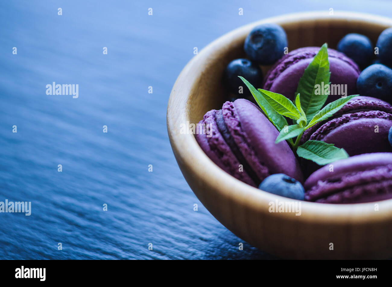 Amaretti rosa con mirtilli su sfondo nero Foto Stock
