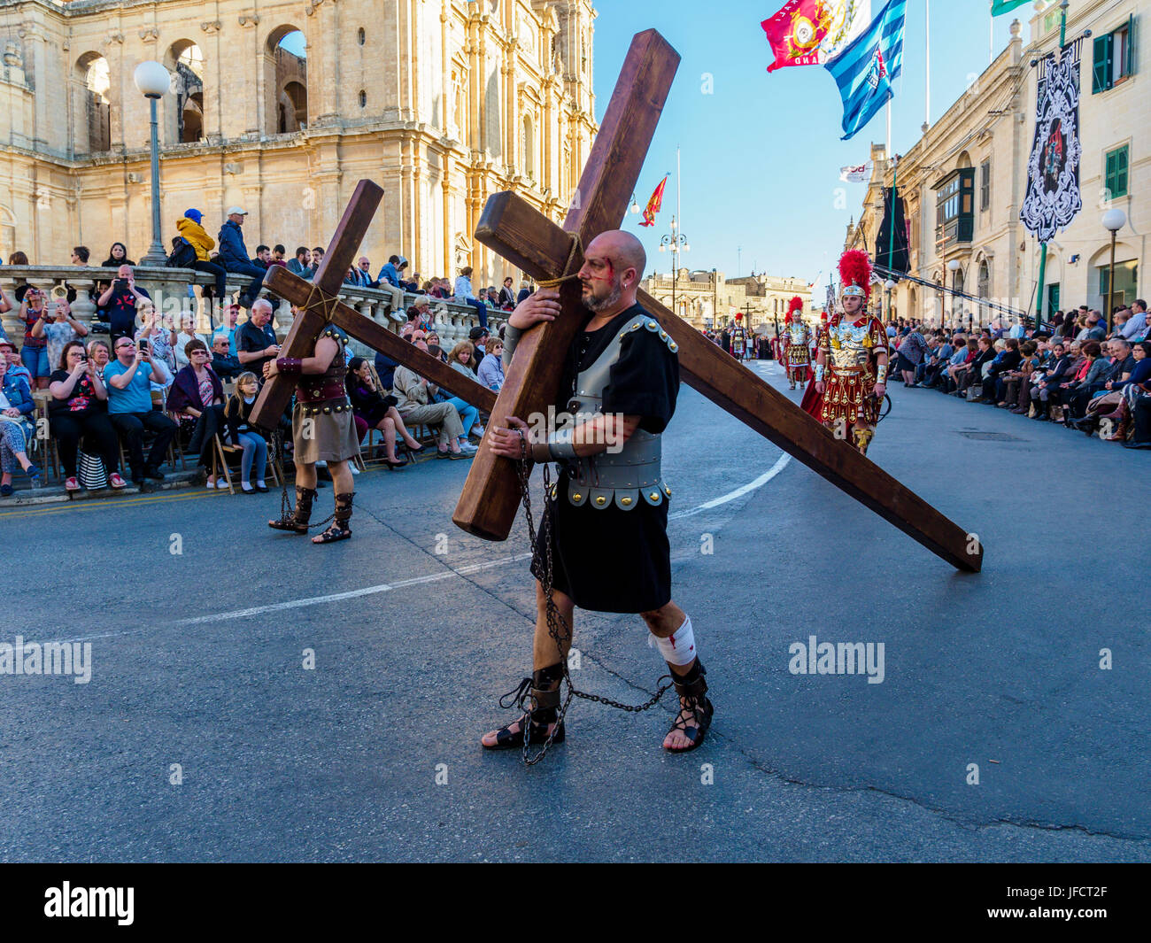 Abitanti di Zejtun / Malta aveva loro tradizionale processione del Venerdì santo di fronte alla loro chiesa, due di esse hanno portato una croce Foto Stock