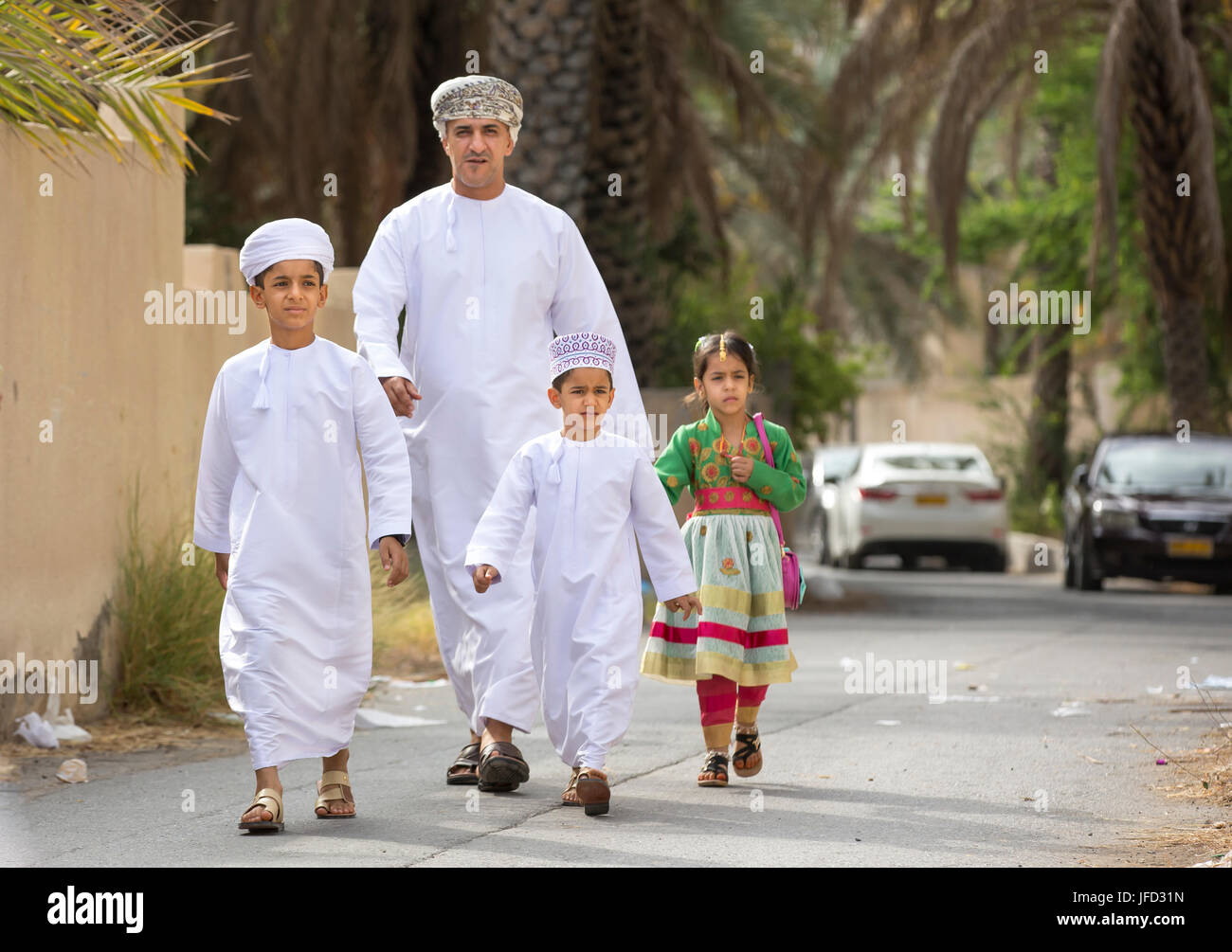 Nizwa, Oman - 26 Giugno 2017: famiglia in abbigliamento tradizionale a un giocattolo sul mercato un giorno di Eid Al Fitr, festa in occasione della fine del mese sacro del Ramadan Foto Stock