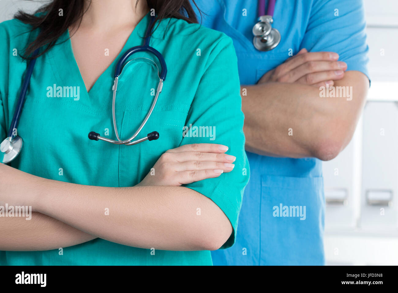 Due medici standind con le braccia incrociate sul petto pronto a lavorare. Sanità e medicina concetto. Foto Stock