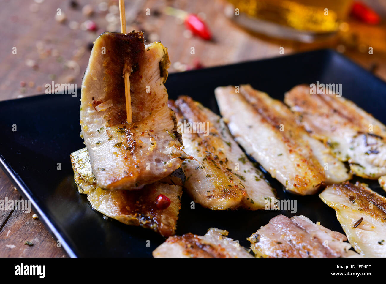 Ingrandimento di una piastra con un po' di spagnolo di filetti di sardine è servita come tapas, su una tavola in legno rustico Foto Stock
