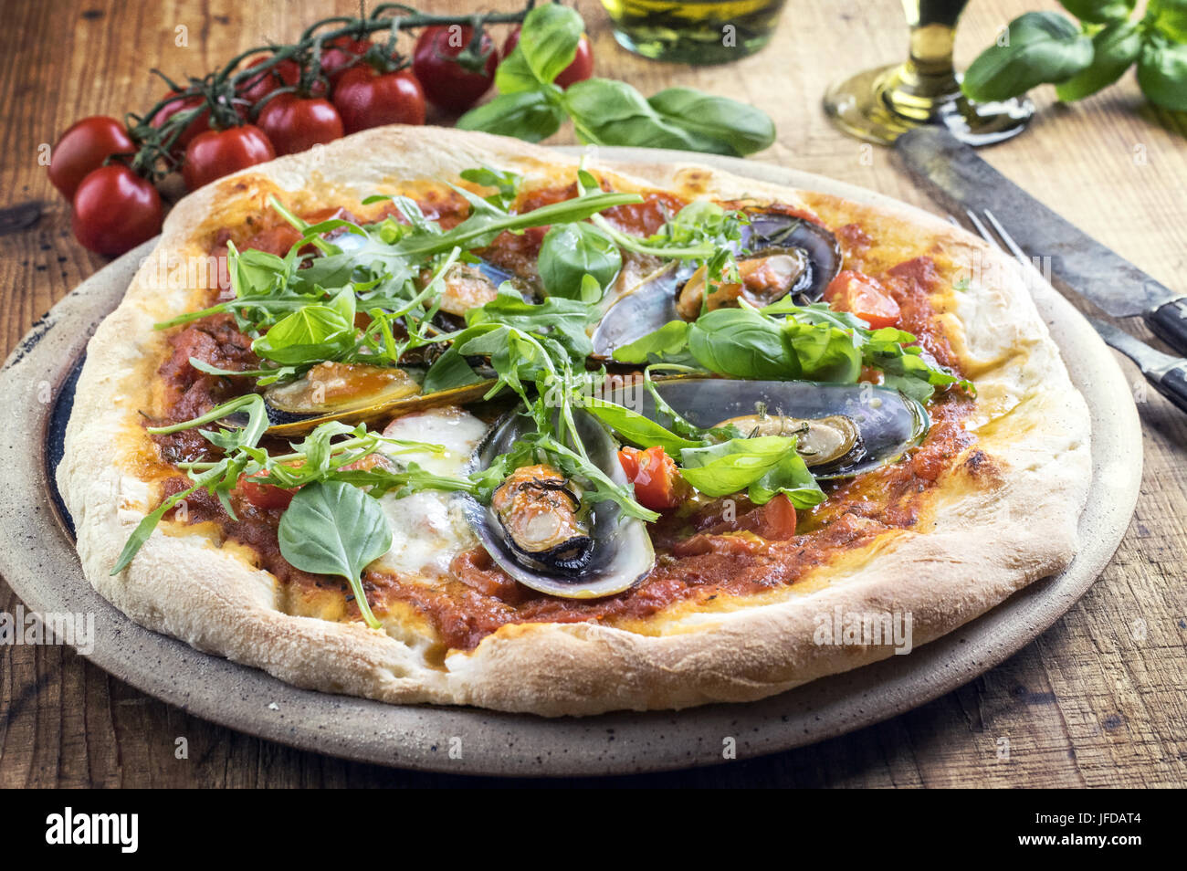 Cozza la pizza con il razzo su una piastra per pizza Foto Stock