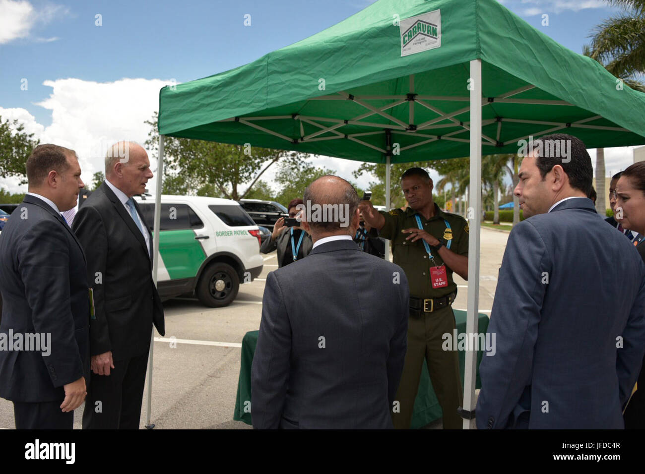 Al porto marittimo di Newark, New Jersey, un ufficiale del CBP monitora le operazioni quando un container marittimo viene caricato su un camion per il trasporto. Ciò garantisce ispezioni e conformità alle normative doganali statunitensi durante le operazioni portuali. Foto Stock