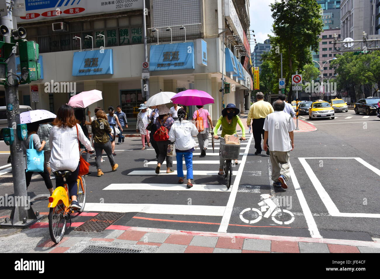 Un sacco di persone stanno attraversando la strada in Taipei vicino Ospedale di Mackay, Taiwan. Temp hit 94F oggi e senza un feltro di Vento implacabile. Foto Stock