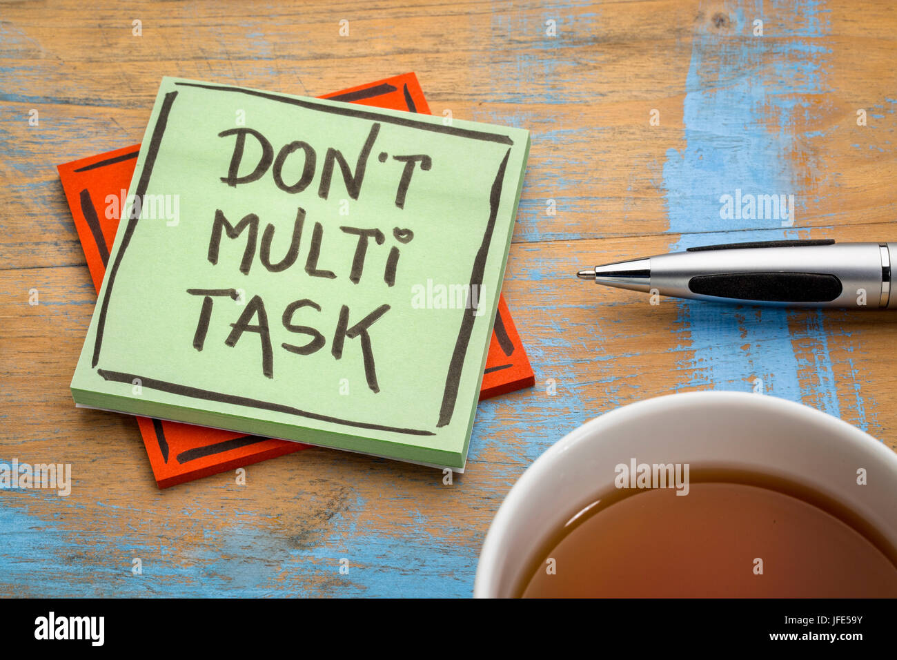 Non effettuano il multitasking - efficienza consigli su una nota adesiva con una tazza di tè Foto Stock