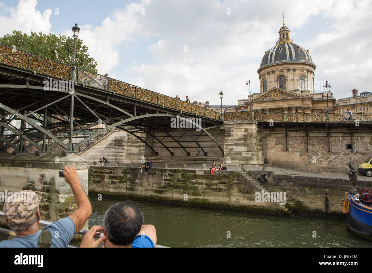 I turisti visualizza l'Istituto Francese e il Pont des Arts, amore o bloccare il ponte, da una barca crociera sul Fiume Senna. Foto Stock