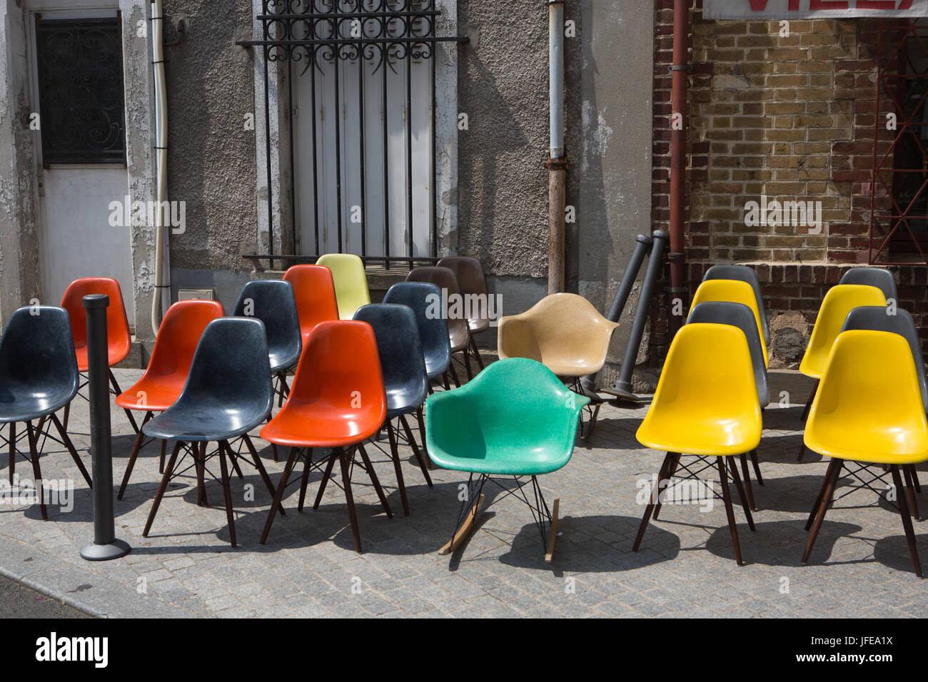 Colorate sedie di plastica sul marciapiede in un esterno di mercato delle pulci. Foto Stock