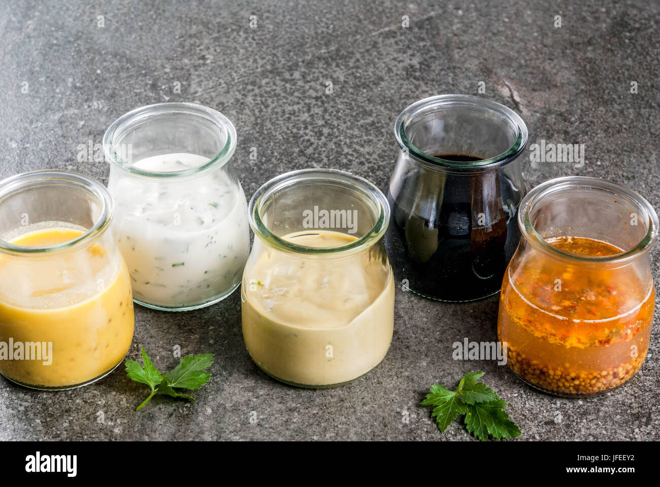 Set di organico dietetici sani condimenti per insalata: salsa vinaigrette, senape, maionese con spezie o ranch, balsamici o soia, basilico con yogurt. 0 Foto Stock