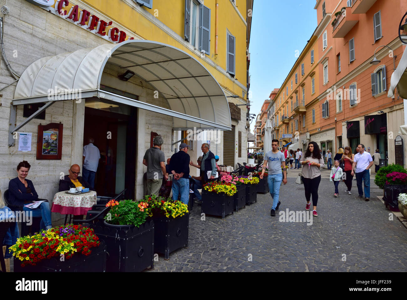 Al di fuori del bar con tavoli e sedie lungo il marciapiede e la vista lungo la strada nel centro Anzio, Italia Foto Stock