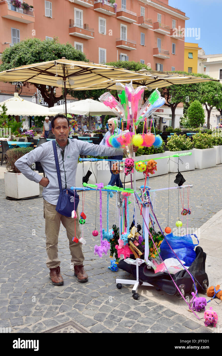 Venditore ambulante con giocattoli per vendere in piedi nel centro di Anzio Piazza Pia plaza Foto Stock