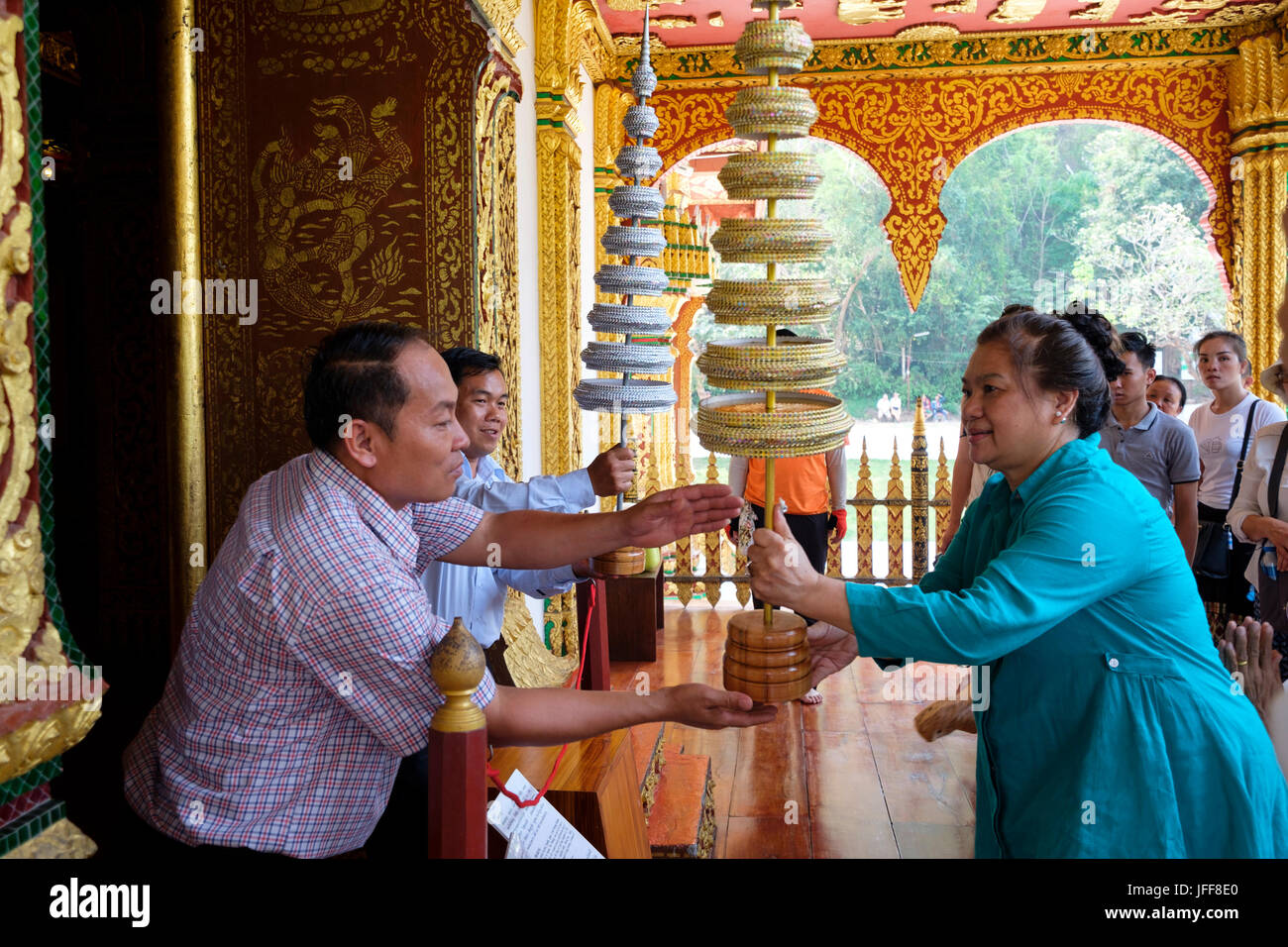 Donna consegna regalo al Buddha a Haw Pha Bang tempio, sul Palazzo Reale motivazione a Luang Prabang, Laos, Asia Foto Stock