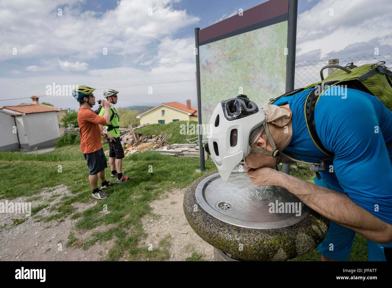 Bikers acqua potabile mentre controllo mappa Foto Stock