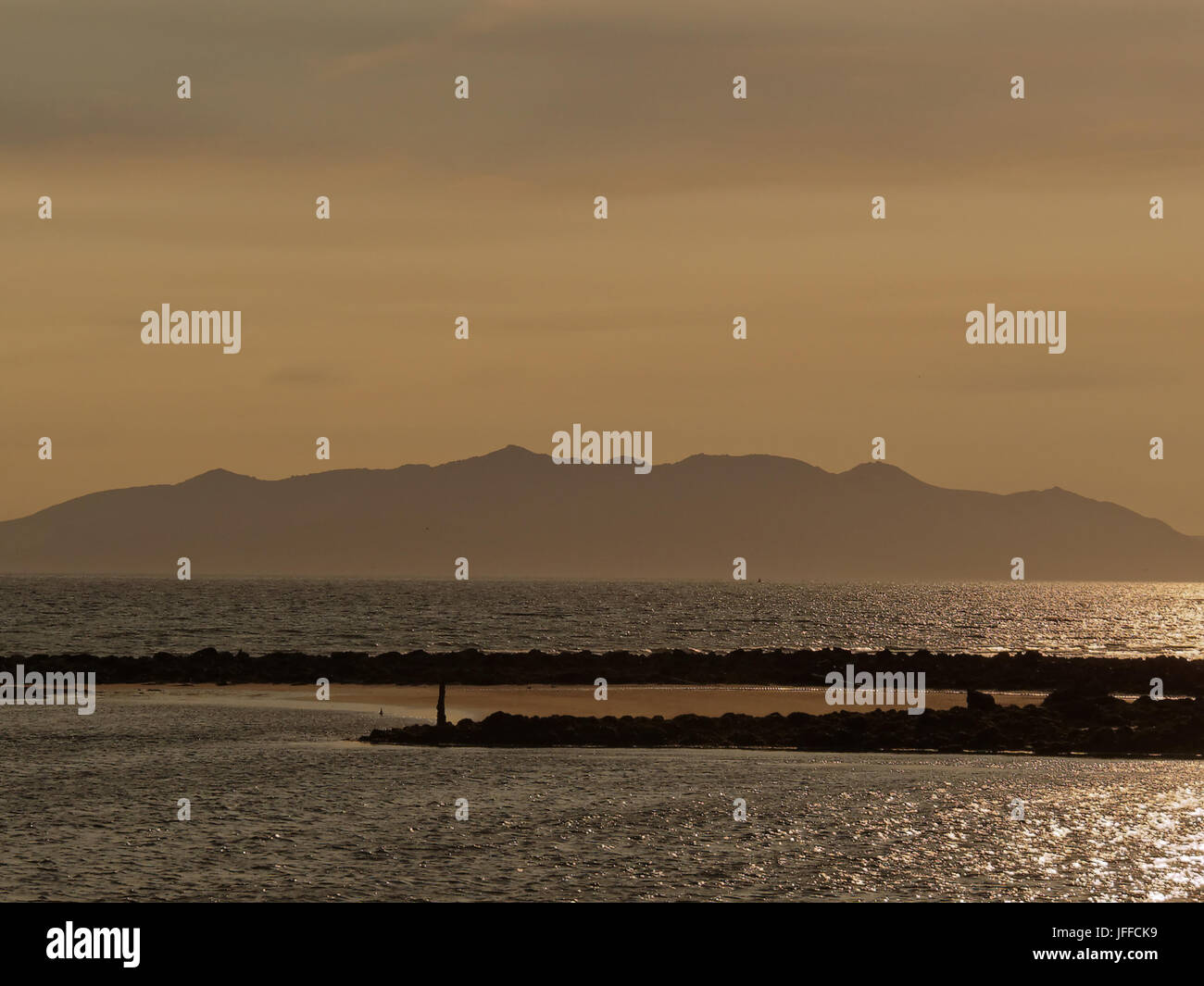 Isola di Arran al crepuscolo da Ayr Beach sunset pensato da molti come l'isola di Avalon della leggenda arturiana Foto Stock