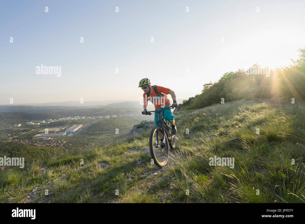 Uomo maturo equitazione mountain bike sulla collina Foto Stock