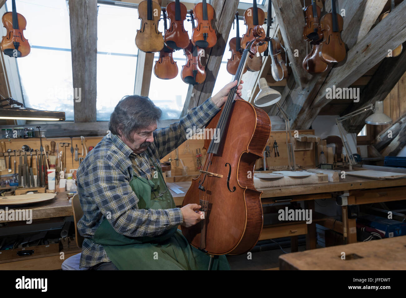 Artigiano che fissa il violino in officina Foto Stock