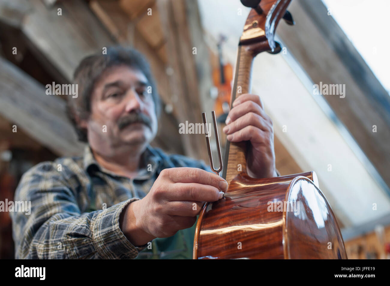 Artigiano in officina di un violino di contenimento Foto Stock