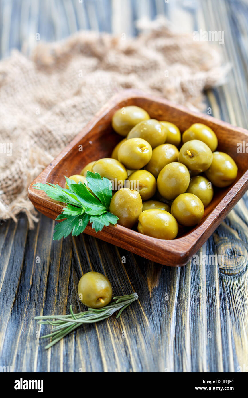 Olive verdi e un rametto di prezzemolo. Foto Stock