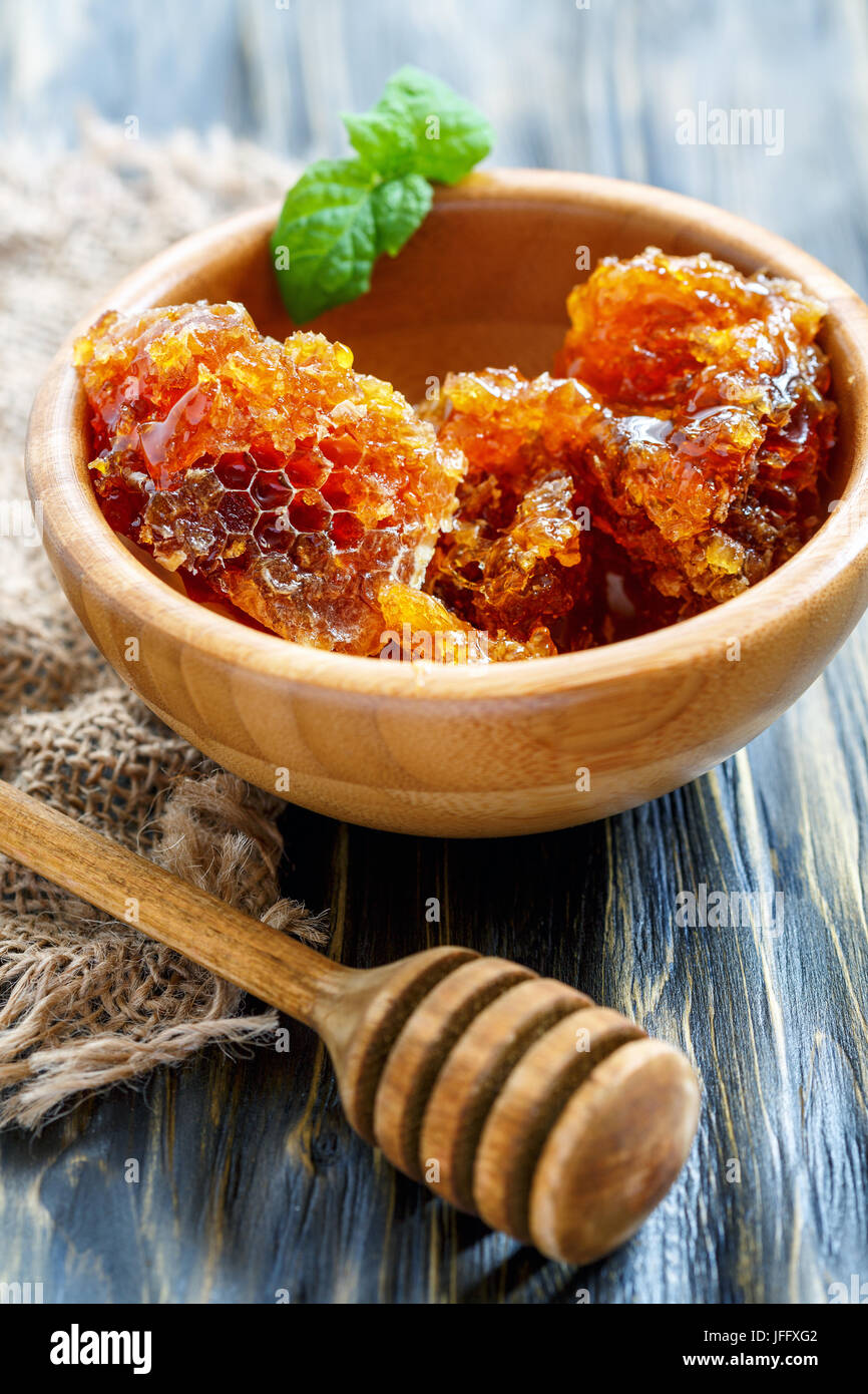 Ciotola di legno con miele e bilanciere. Foto Stock