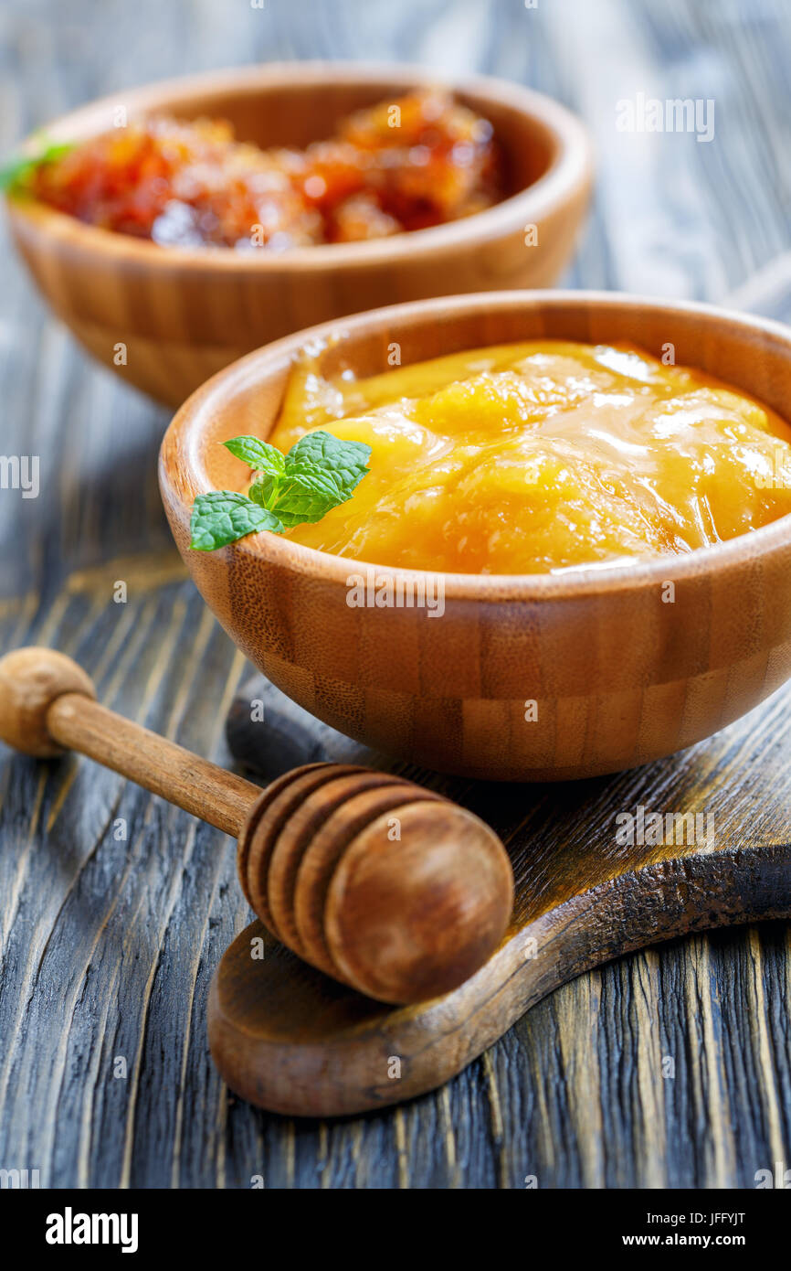 Ciotola di legno con miele e bilanciere. Foto Stock