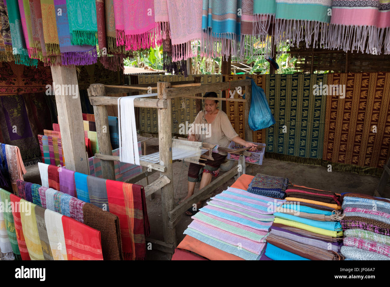 Il vecchio donna al lavoro su un telaio di tessitura nel villaggio di Ban Xang Hai, Laos, Asia Foto Stock