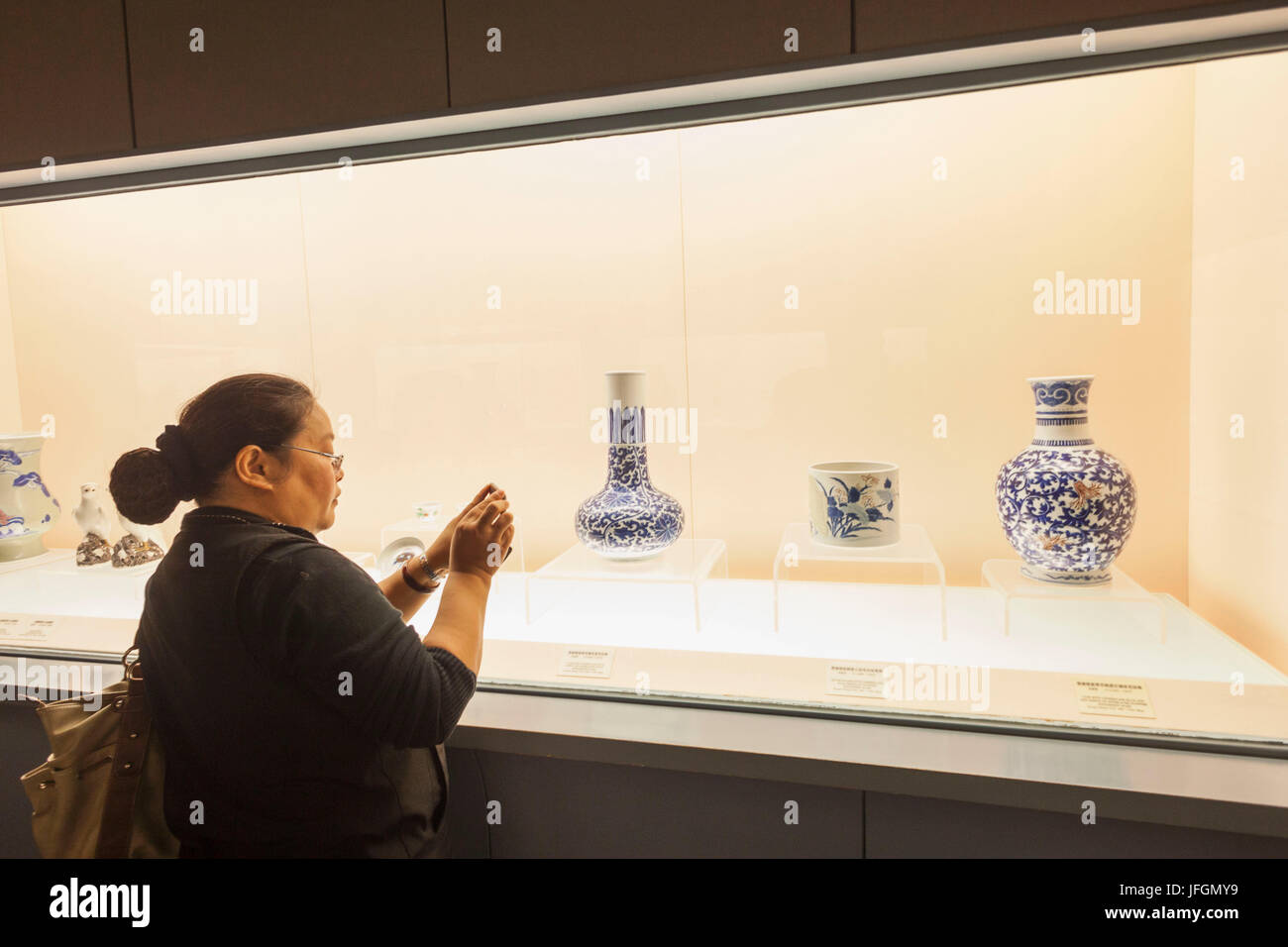 Cina, Shanghai, il Museo di Shanghai, ragazza prendendo foto di antiche ceramiche Display Foto Stock