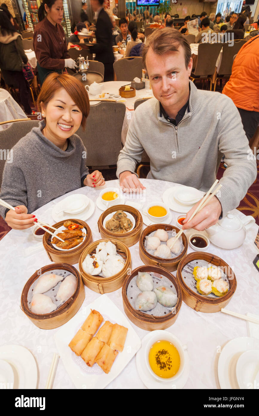Cina, Hong Kong, giovane mangiare Dim Sum Foto Stock