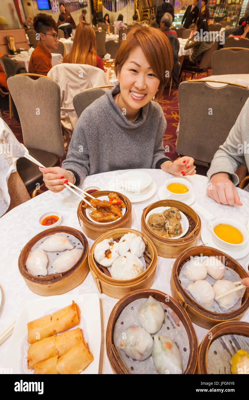 Cina, Hong Kong, Donna mangiare Dim Sum Foto Stock