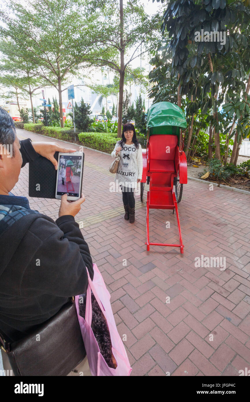 Cina, Hong Kong, centro turistico cinese che posano per una foto accanto al Rickshaw Foto Stock