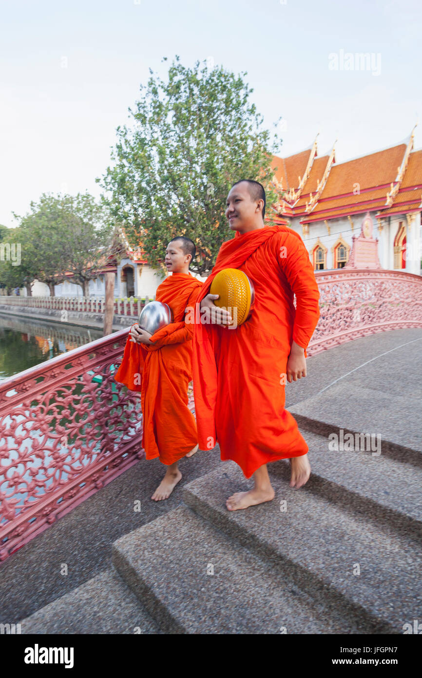 Thailandia, Bangkok, Wat Benchamabophit aka il tempio in marmo, monaci Camminando sul ponte ad arco Foto Stock