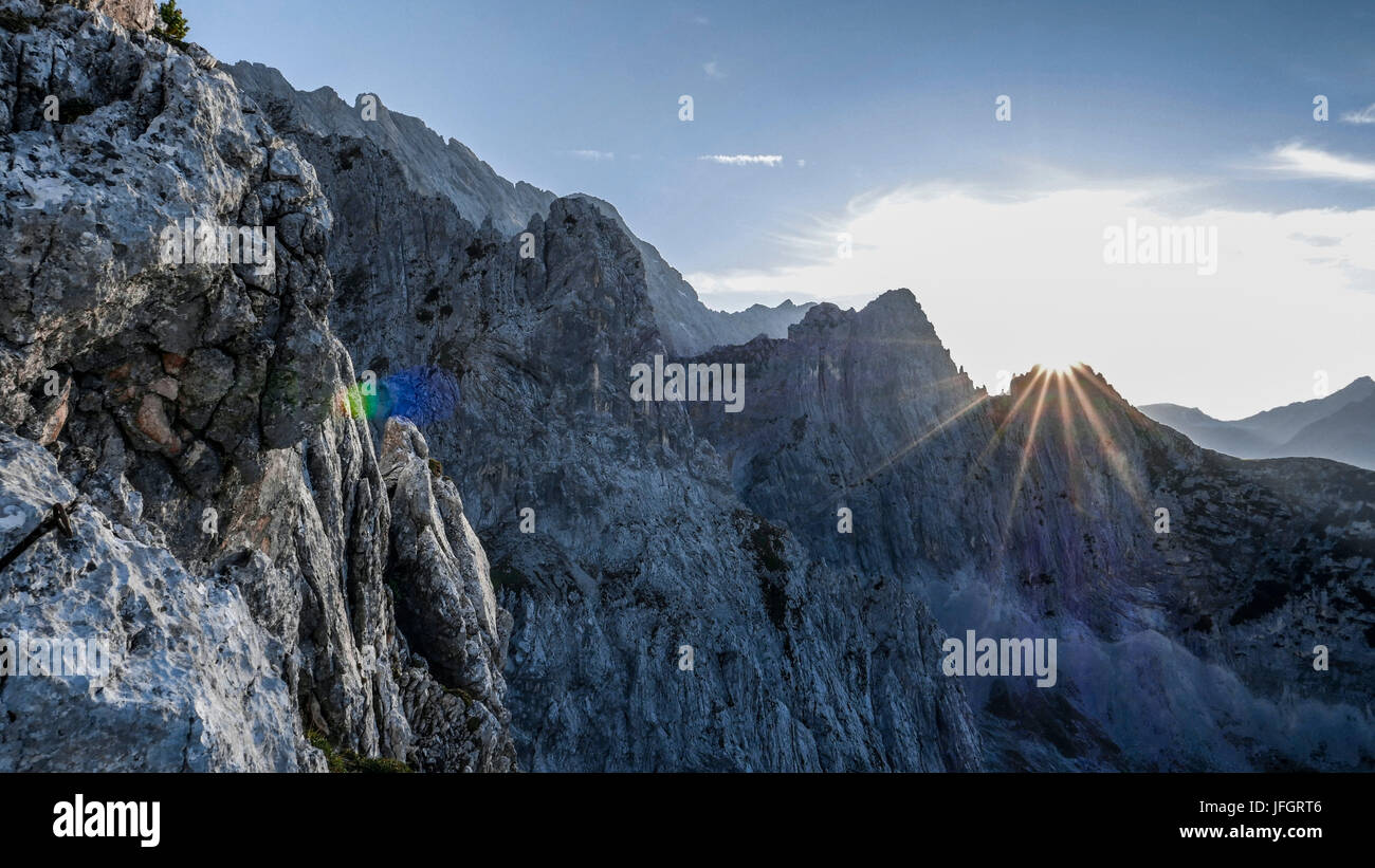 Paesaggio di roccia, luce posteriore e sunray sulle piccole Hundsstallkopf, vista del Zundernkamm, sulla sinistra di fronte a nord-ovest Zunderkopf, sulla destra dietro il massiccio dello Zugspitze, gamma di Wetterstein, Alta Baviera Foto Stock