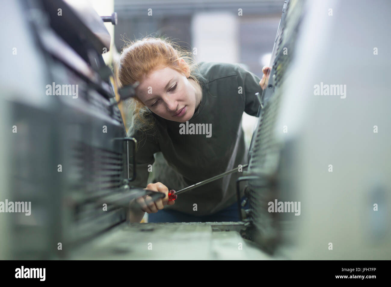 Operatore di stampa riparazione macchina di stampa con il driver della vite Foto Stock