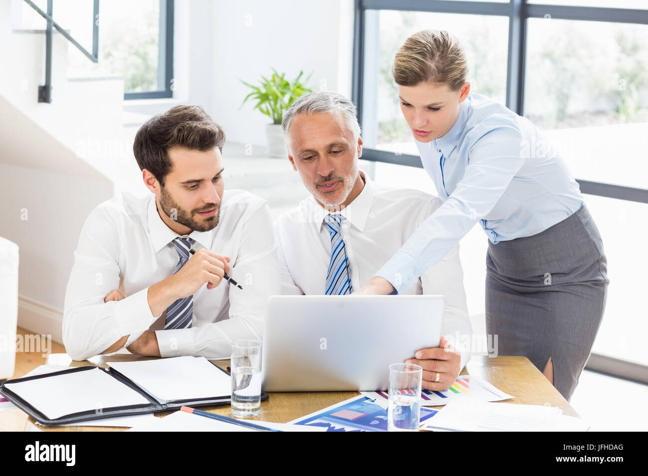 Colleghi di lavoro per discutere il lavoro di ufficio su laptop Foto Stock