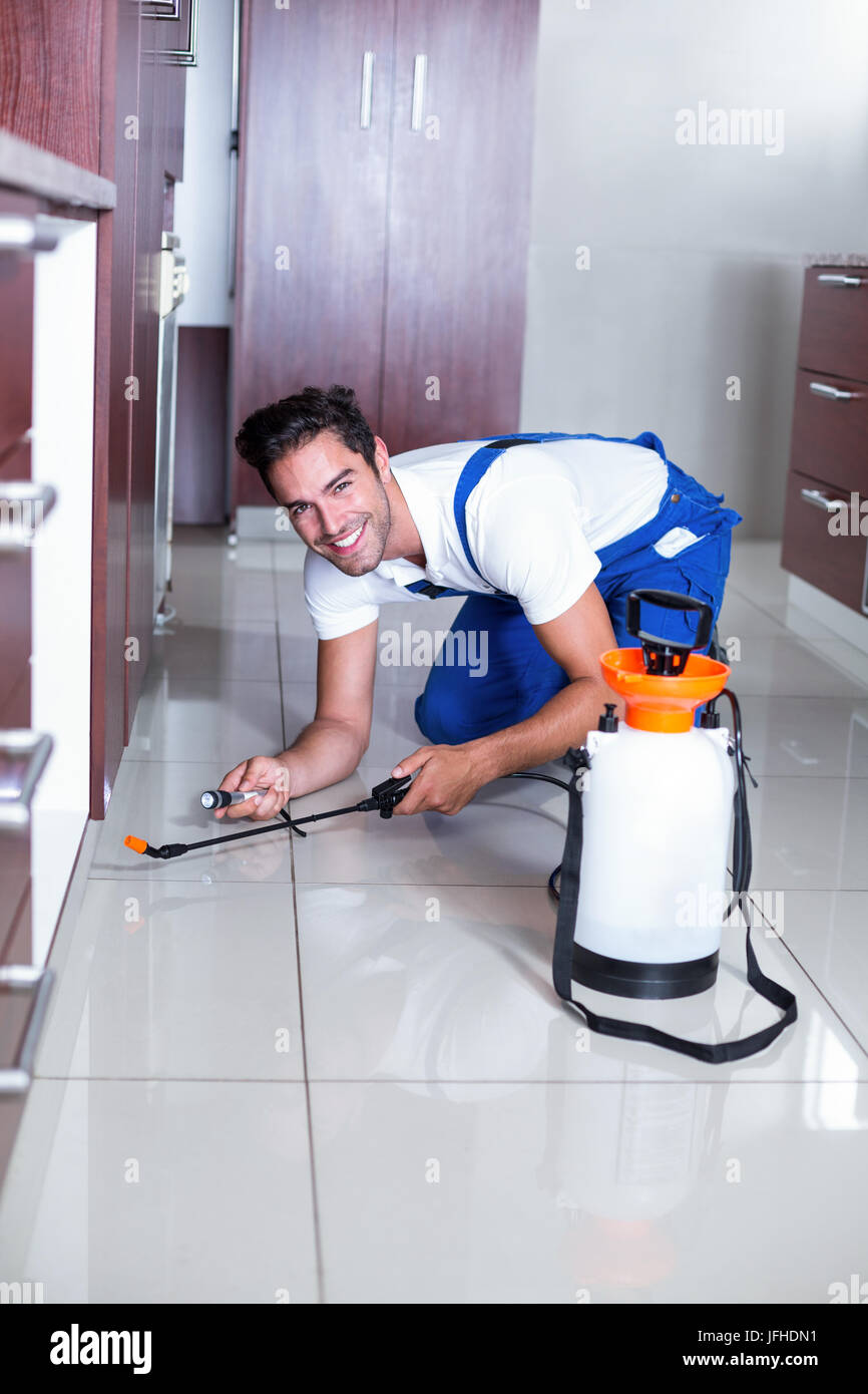 Allegro uomo utilizzando la torcia mentre spruzzando insetticidi Foto Stock