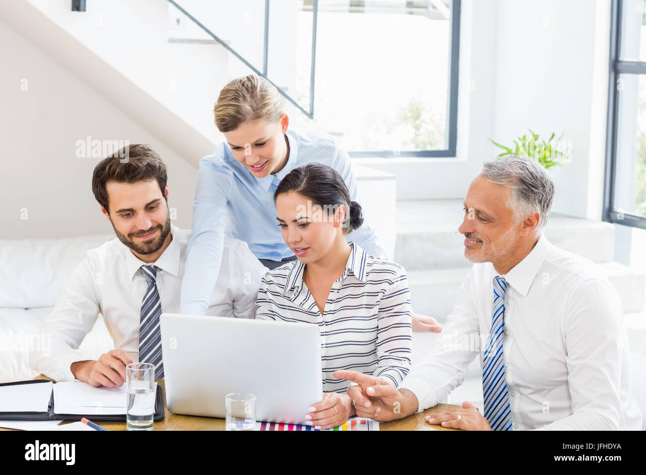 Colleghi di lavoro per discutere il lavoro di ufficio su laptop Foto Stock