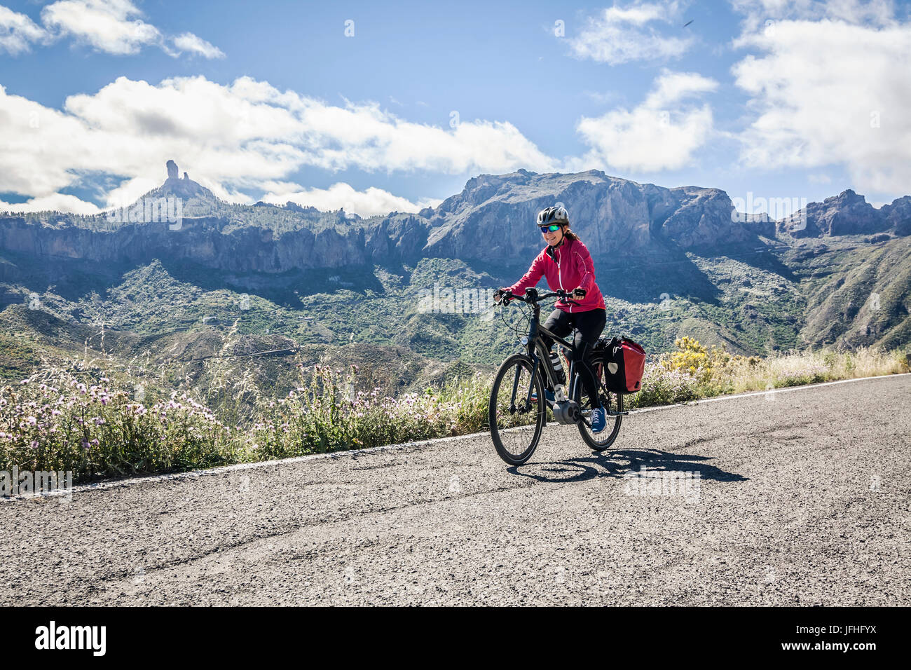 La donna in sella della bicicletta elettrica su strada di montagna Foto Stock