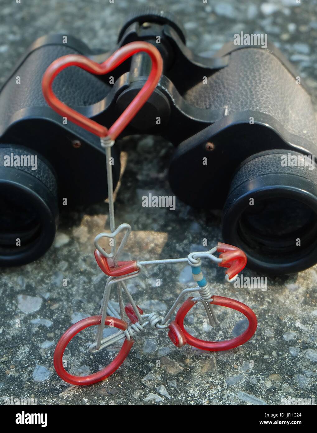 Classic nero metallico binocolo o campo di occhiali e bicicletta figura con cuore rosso, concetto romantico per trovare un amore da lontano. Foto Stock