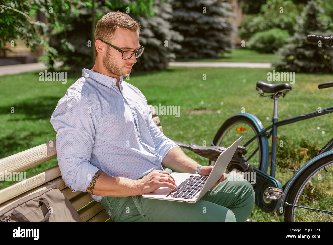 Primo piano di imprenditore mani digitazione sul portatile durante le pause caffè nel parco. Imprenditore Casual seduta su una panchina e lavoro, accanto al banco di appoggio di una b Foto Stock