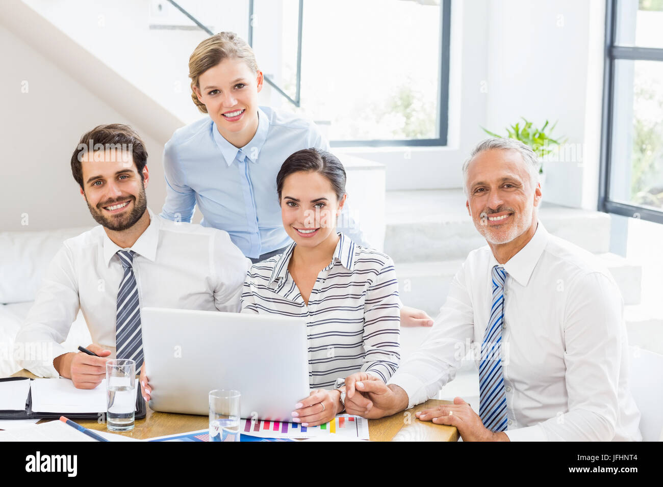 Ritratto di happy business i colleghi a lavorare alla scrivania Foto Stock