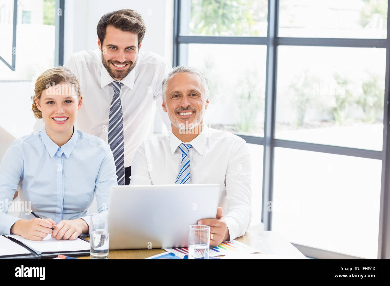 Ritratto di happy business i colleghi a lavorare alla scrivania Foto Stock