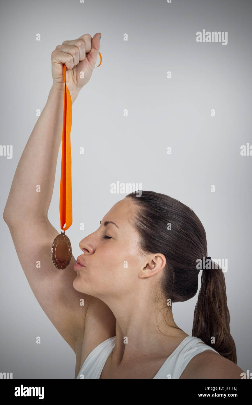 Immagine composita di felice atleta kissing medaglia Foto Stock