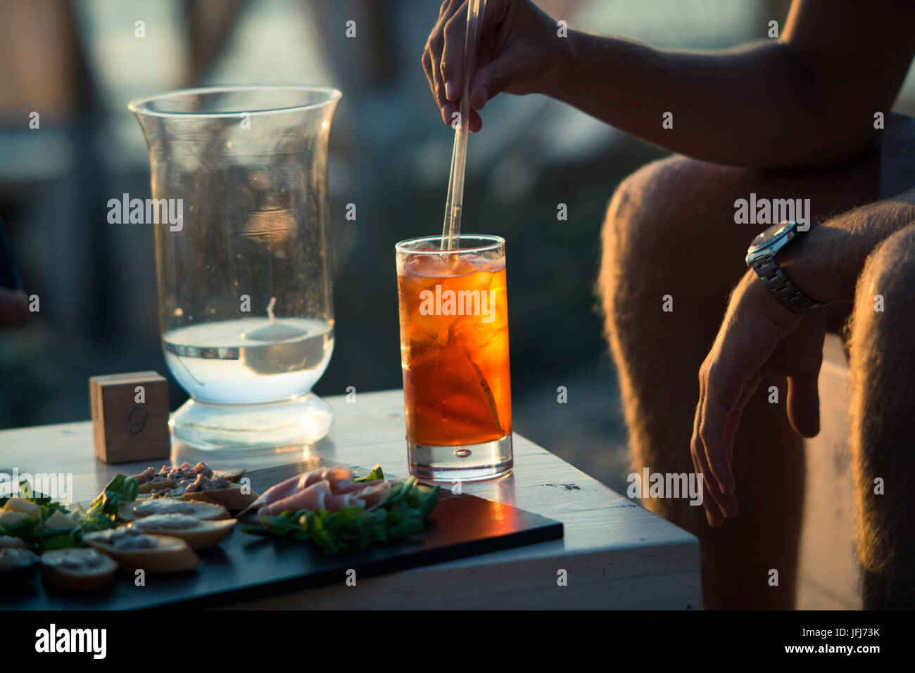 L'uomo suscita drink nel bar sulla spiaggia Foto Stock