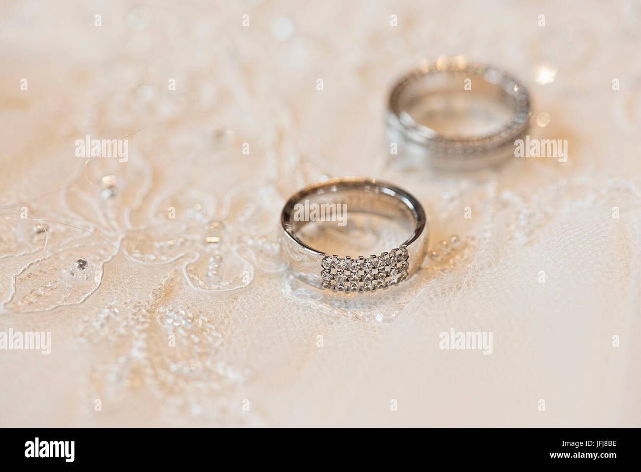 Gli anelli di nozze di platino con diamanti su uno sfondo costituito di lacy Foto Stock