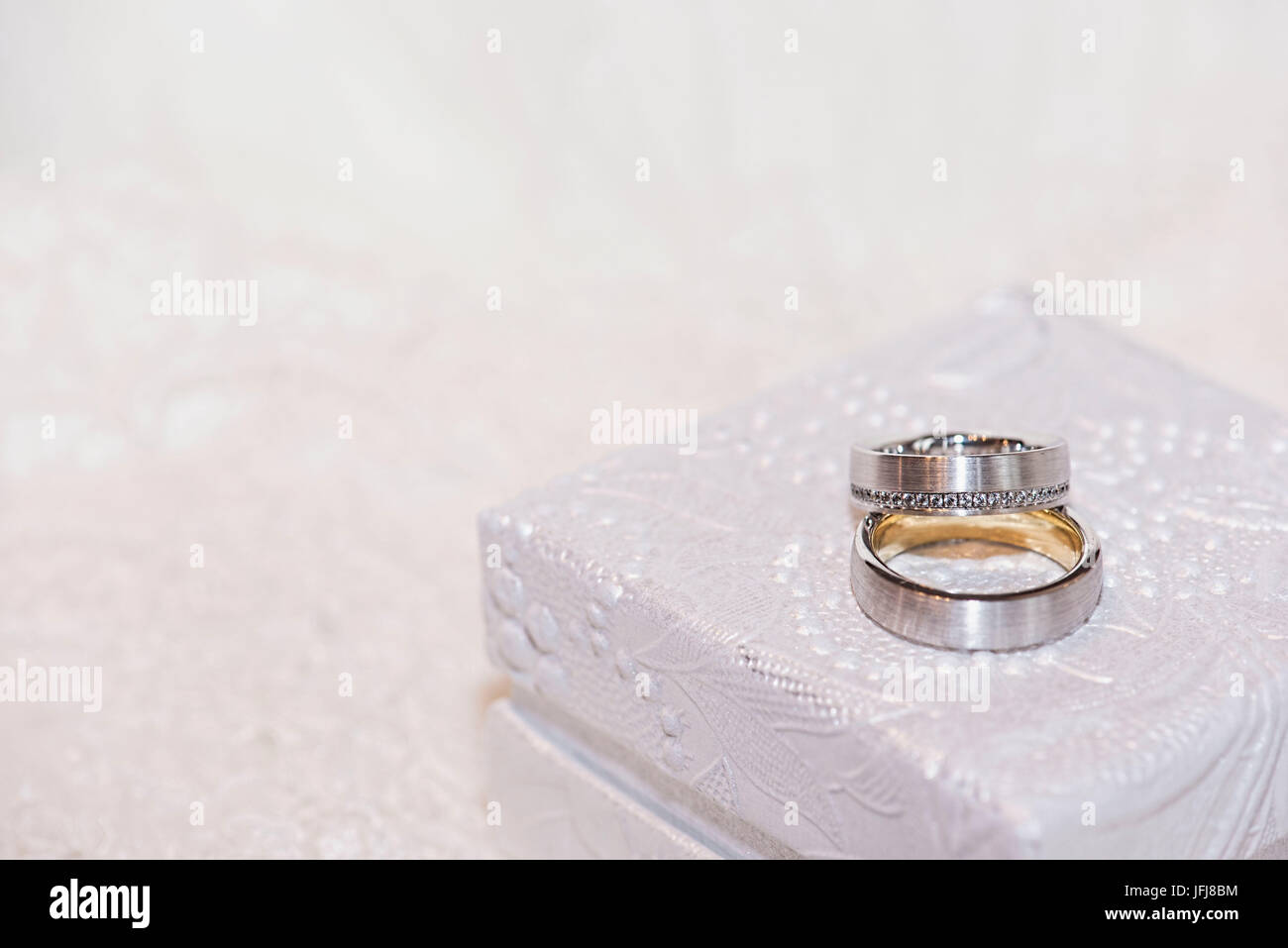 Gli anelli di nozze in oro e platino con diamanti su bianco preziosi gioielli box Foto Stock