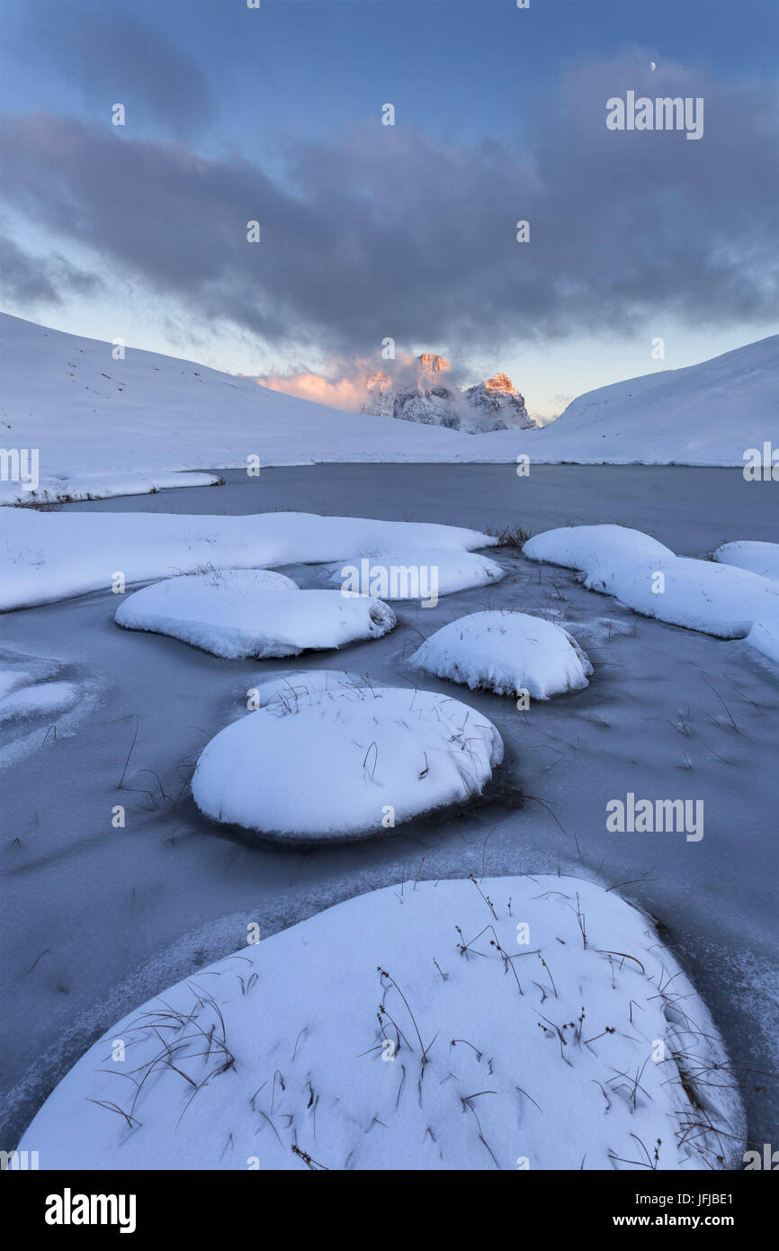 L'Europa, Italia, Veneto, Falzarego, Belluno, neve fresca e ghiaccio presso il lago di imbastire, sullo sfondo il Monte Pelmo parzialmente nascosto dalle nuvole, Mondeval, Dolomiti Foto Stock