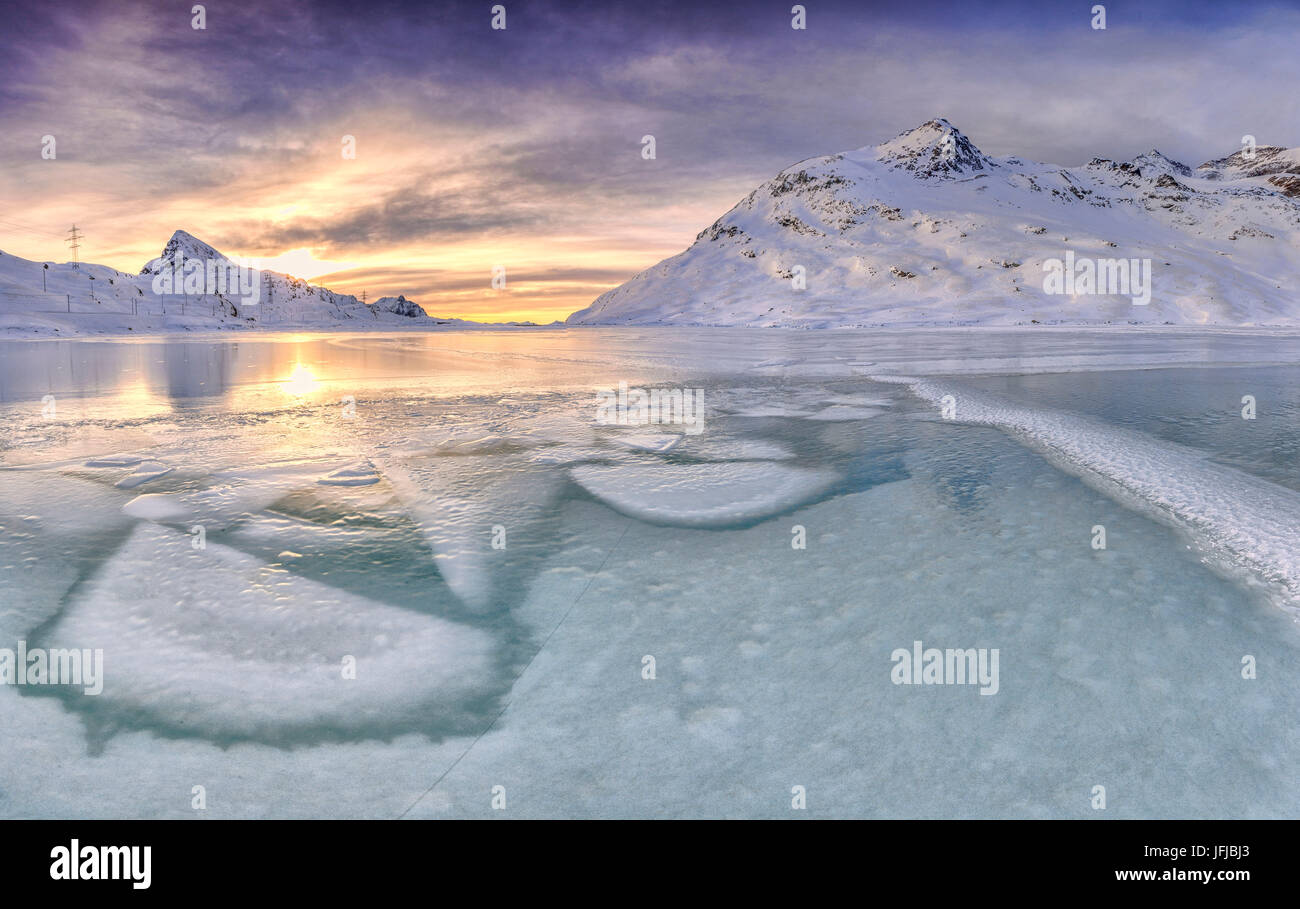 Alba illumina la superficie frozens ok Lago Bianco al Passo Bernina, Cantone dei Grigioni, Engadina, Svizzera, Europa Foto Stock