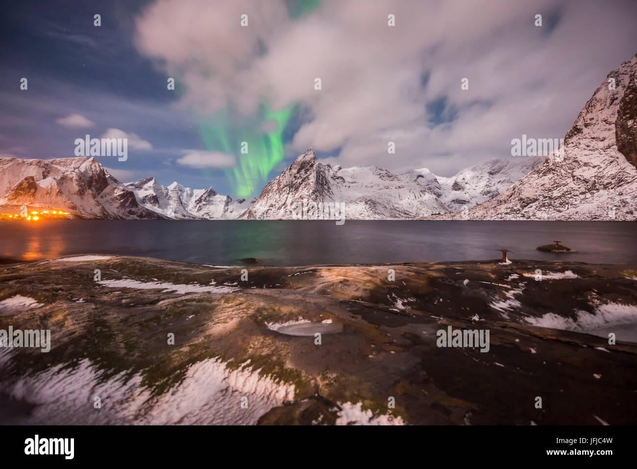 Piccola aurora di nuvole, roccia e ghiaccio, vicino all'oceano, le piccole città e le montagne sul retro, Hamnoy Isola, Lofoten, Norvegia Foto Stock